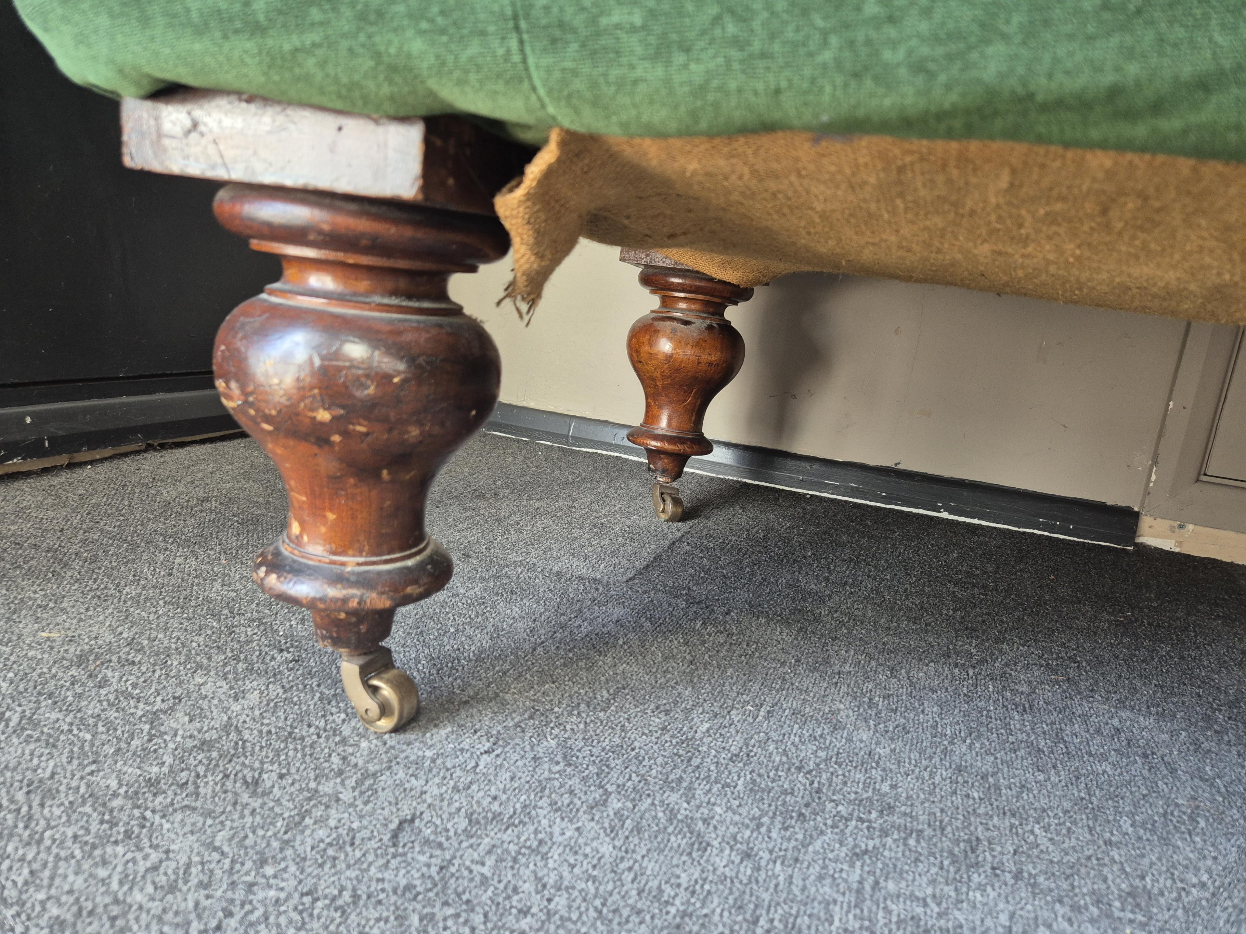 A Victorian mahogany settee upholstered in deep buttoned green velvet, width 210cm, depth 80cm, height 74cm. Condition - fair